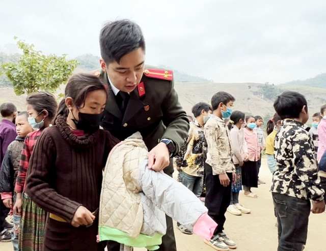 Anh Dương Hải Anh tặng áo cho học sinh vùng cao. Ảnh: NVCC