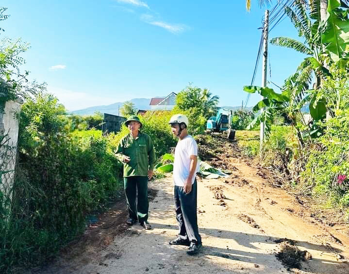 Ông Mã Văn Thủy (áo xanh) vận động người dân hiến đất, mở rộng đường. Ảnh: Tạ Lan Ông Mã Văn Thủy (áo xanh) vận động người dân hiến đất, mở rộng đường. Ảnh: Tạ Lan