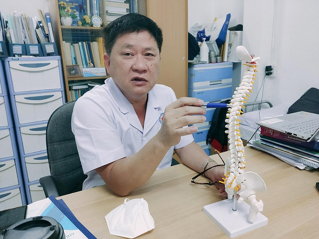 Sinh tồn hậu chấn thương tủy sống: Đi ra từ bóng tối tuyệt vọng - Ảnh 1. Bác sĩ Đinh Quang Thanh thông tin về mô hình cột sống. Ảnh: NHƯ LỊCH