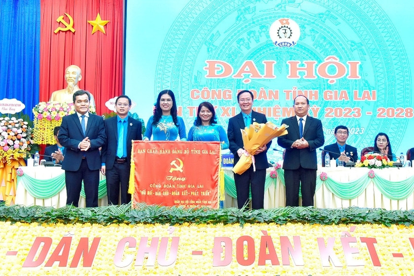 Ủy viên Ban Chấp hành Trung ương Đảng, Bí thư Tỉnh ủy, Chủ tịch HĐND tỉnh Hồ Văn Niên (bìa trái) và Phó Bí thư Tỉnh ủy Rah Lan Chung (bìa phải) trao tặng bức trướng của Ban Chấp hành Đảng bộ tỉnh cho Công đoàn tỉnh Gia Lai với nội dung: “Đổi mới-Dân chủ-Đoàn kết-Phát triển”. Ảnh: Đức Thụy