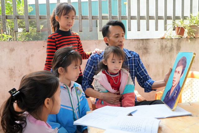 Anh Hồ Công Được và các con, cháu bên di ảnh liệt sĩ Hồ Công Đệ. Ảnh: Lê Nam Anh Hồ Công Được và các con, cháu bên di ảnh liệt sĩ Hồ Công Đệ. Ảnh: Lê Nam