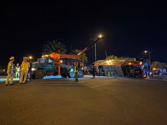 Lực lượng chức năng dùng xe cẩu để lật xe khách lại. Ảnh: Thanh Quân