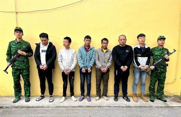 Hai đối tượng Trần Văn Binh và Dường Cắm Ngằn cầm biển đứng giữa 4 đối tượng người Trung Quốc. Ảnh: TTXVN phát