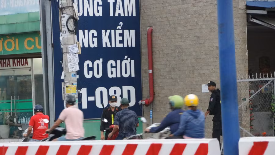 Lực lượng chức năng phong tỏa phía trước Trung tâm đăng kiểm xe cơ giới 61-08D. Ảnh: Đình Trọng Lực lượng chức năng phong tỏa phía trước Trung tâm đăng kiểm xe cơ giới 61-08D. Ảnh: Đình Trọng