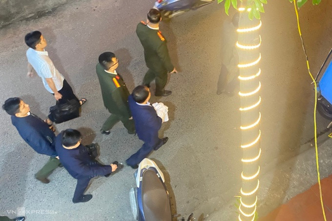 Ông Nguyễn Đình Đương (tay che khăn trắng) bị công an dẫn đi. Ảnh: Lê Tân Ông Nguyễn Đình Đương (tay che khăn trắng) bị công an dẫn đi. Ảnh: Lê Tân