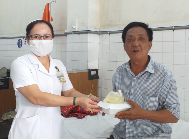 Dĩa cơm biết... hát - Ảnh 1. Bệnh nhân nghèo được nhận suất ăn miễn phí nhờ bác sĩ đi hát gây quỹ. Ảnh: Quang Viên