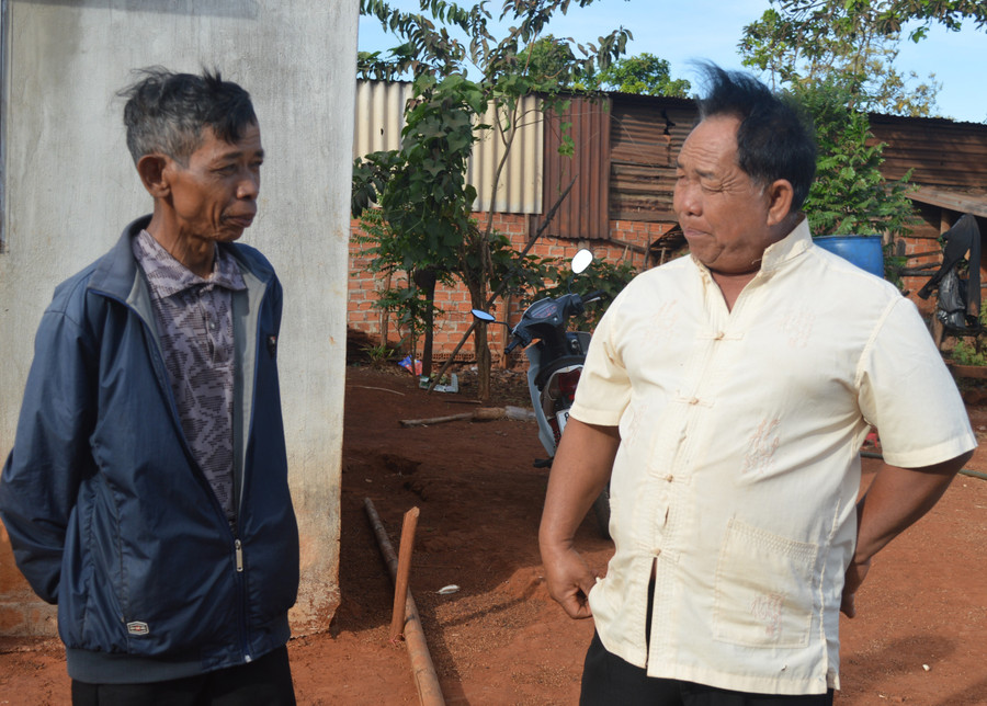 Ông Mrơp (bên phải) trò chuyện cùng dân làng. Ảnh: Phương Dung