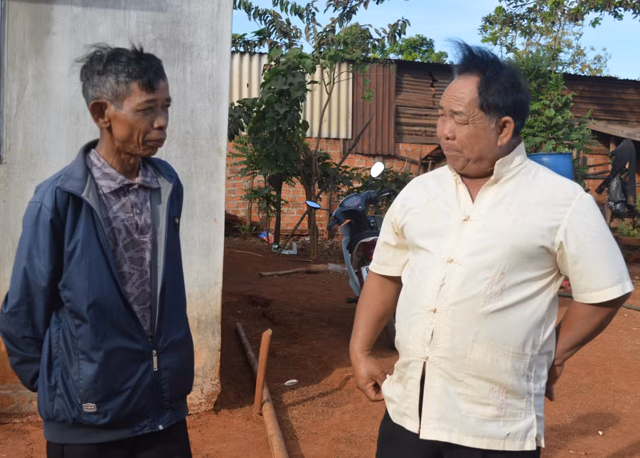 Ông Mrơp (bên phải) trò chuyện cùng dân làng. Ảnh: Phương Dung