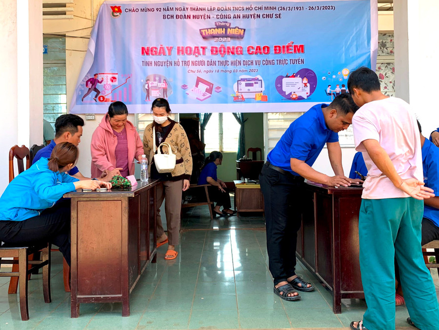 Đoàn viên, thanh niên huyện Chư Sê hướng dẫn người dân cài đặt ứng dụng VNeID trên điện thoại. Ảnh: Mỹ Đức
