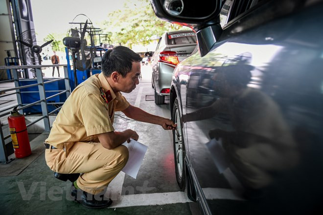 50 cán bộ kiểm định của lực lượng CSGT tăng cường cho công tác đăng kiểm đã bắt tay vào công việc hỗ trợ các trung tâm đăng kiểm. Trong đó, 30 cán bộ CSGT được tăng cường cho 10 trung tâm tại Hà Nội và 20 người cho 9 trung tâm ở Thành phố Hồ Chí Minh. Ảnh: Hoài Nam/Vietnam+ 50 cán bộ kiểm định của lực lượng CSGT tăng cường cho công tác đăng kiểm đã bắt tay vào công việc hỗ trợ các trung tâm đăng kiểm. Trong đó, 30 cán bộ CSGT được tăng cường cho 10 trung tâm tại Hà Nội và 20 người cho 9 trung tâm ở Thành phố Hồ Chí Minh. Ảnh: Hoài Nam/Vietnam+