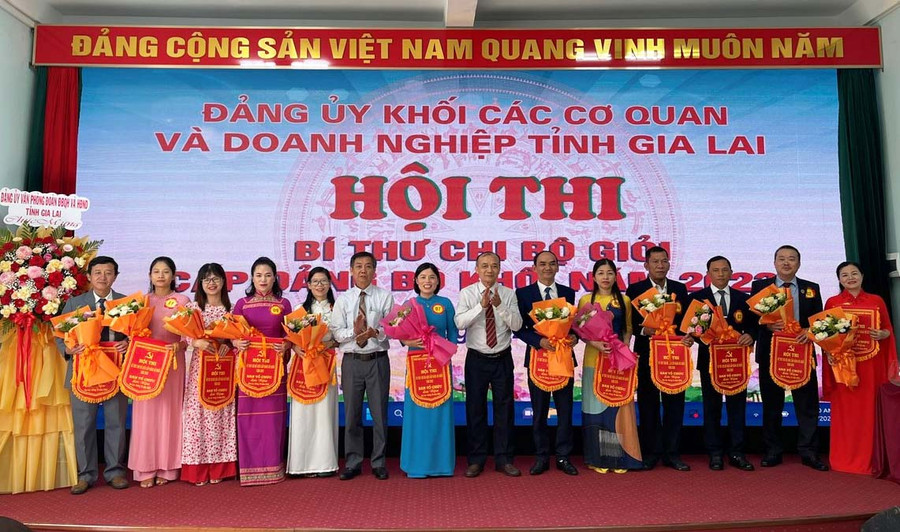 Bí thư Đảng ủy Khối các Cơ quan và Doanh nghiệp tỉnh Huỳnh Minh Thuận (thứ 7 từ phải qua) tặng cờ và hoa chúc mừng các thí sinh tham gia hội thi bí thư chi bộ giỏi cấp đảng bộ khối năm 2023. Ảnh: A.H
