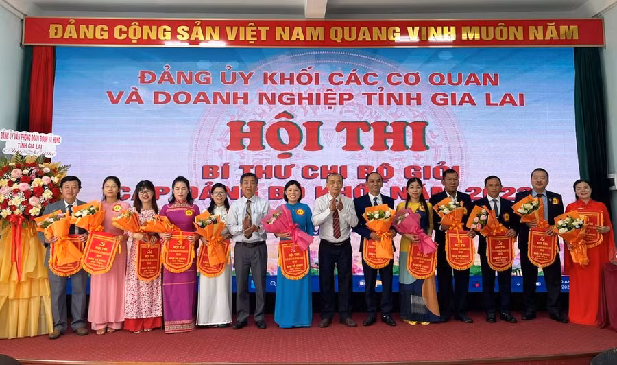 Bí thư Đảng ủy Khối các Cơ quan và Doanh nghiệp tỉnh Huỳnh Minh Thuận (thứ 7 từ phải qua) tặng cờ và hoa chúc mừng các thí sinh tham gia hội thi bí thư chi bộ giỏi cấp đảng bộ khối năm 2023. Ảnh: A.H