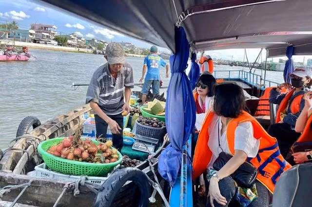 Du khách thưởng thức trái cây tại chợ nổi Cái Răng (Cần Thơ)