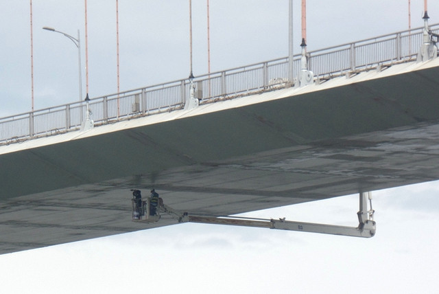 Cảnh làm việc trên “gàu” xe chuyên dụng khiến người chứng kiến thót tim. Ảnh: HOÀNG SƠN 'Biệt đội' chăm sóc những cây cầu - Ảnh 4.