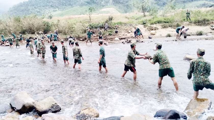 Cán bộ, chiến sĩ Sư đoàn Bộ binh 2 (Quân khu 5) giúp người dân xã Kon Pne (huyện Kbang) đắp kè đập dân sinh dẫn nước về cánh đồng. Ảnh: Minh Nguyễn