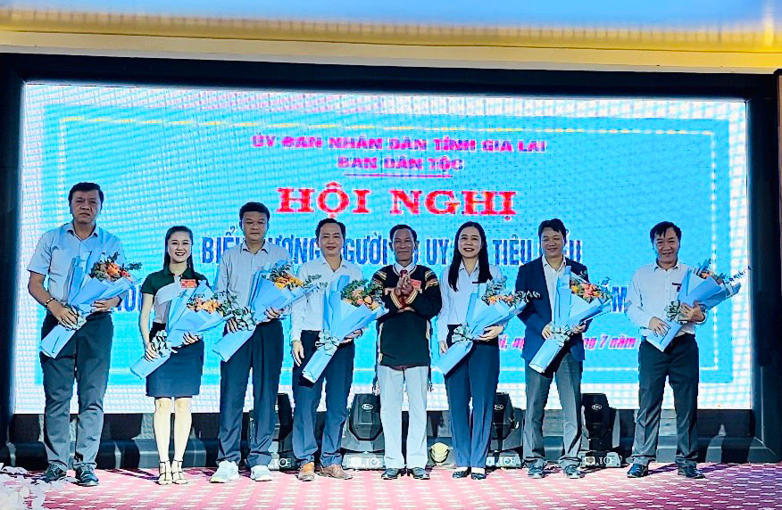 Lãnh đạo Ban Dân tộc tỉnh tặng hoa cảm ơn các cơ quan, doanh nghiệp đã hỗ trợ xe đạp cho các em học sinh người DTTS. Ảnh: Hải Bình