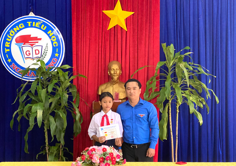 Anh Đỗ Duy Nam-Phó Bí thư Tỉnh Đoàn Gia Lai trao Huy hiệu “Tuổi trẻ dũng cảm” cho em Rơ Châm Ư (học sinh lớp 5G, Trường Tiểu học Nghĩa Hưng, huyện Chư Pah). Ảnh: Hà Đức Thành