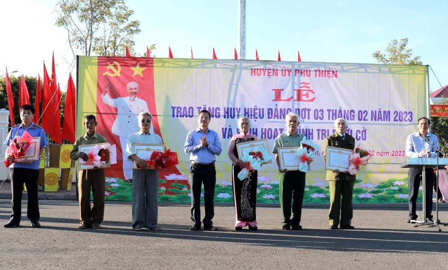 Bí thư Huyện ủy Phú Thiện Nguyễn Hoàng Phong (thứ 4 từ trái sang) trao huy hiệu Đảng cho các đảng viên tại buổi sinh hoạt chính trị dưới cờ (ảnh Ban Tuyên giáo Huyện ủy Phú Thiện cung cấp).