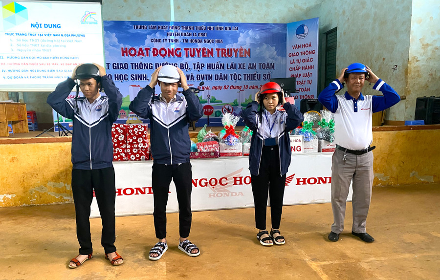 Các em học sinh Trường THPT A Sanh được hướng dẫn đội mũ bảo hiểm đúng cách. Ảnh: Hà Đức Thành