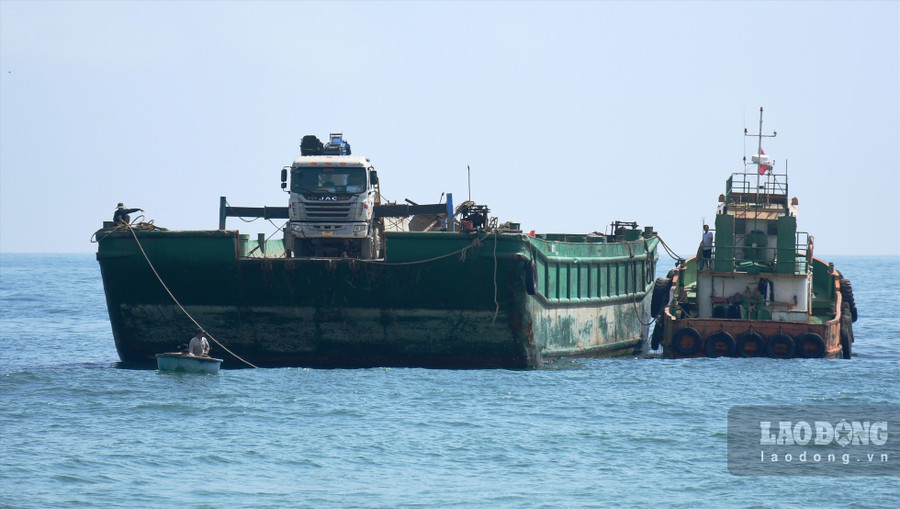 Chủ tàu đưa xe cẩu ra biển, tiếp cận tàu Hoàng Gia 46 để cẩu hàng hóa trong tàu Hoàng Gia 46 lên bờ. Ảnh: Ngọc Viên