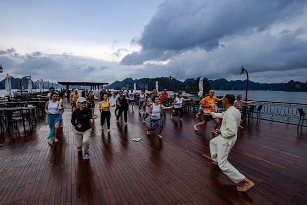 Du khách nghỉ dưỡng trên du thuyền tại vịnh Hạ Long kết hợp tập Taichi. Ảnh: CTV/Vietnam+ Du khách nghỉ dưỡng trên du thuyền tại vịnh Hạ Long kết hợp tập Taichi. Ảnh: CTV/Vietnam+