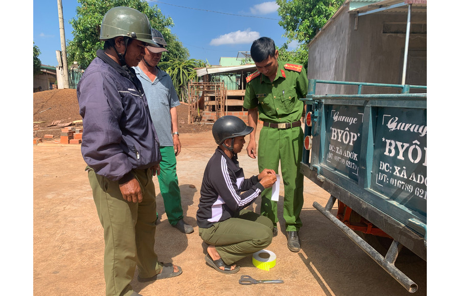 Công an xã Adơk (huyện Đak Đoa) dán phản quang miễn phí trên xe công nông của người dân. Ảnh: L.A