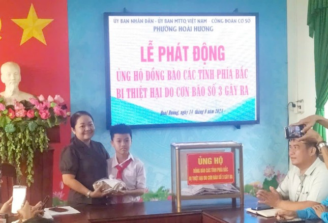 Sáng nay (14/9), em Trịnh Hồng Vinh cùng mẹ mang số tiền gom góp được tới trụ sở phường Hoài Hương để ủng hộ. Ảnh: Gia đình cung cấp