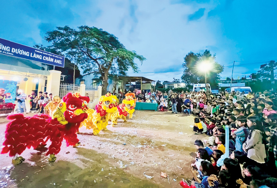Các em thiếu nhi làng Châm Anel và Ngol Tảl (phường Chi Lăng, TP. Pleiku) thích thú xem múa lân. Ảnh: P.L