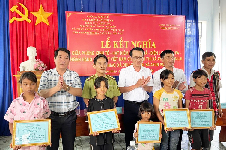 Các cơ quan, đơn vị kết nghĩa trao tặng 5 suất quà cho trẻ em mồ côi tại buôn Hiao, xã Chư Băh. Ảnh: Vũ Chi