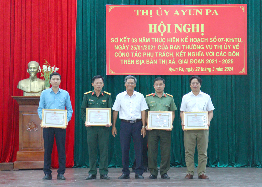 Phó Bí thư Thường trực Thị ủy Ayun Pa Ksor Vinh trao giấy khen của Ban Thường vụ Thị ủy cho các tập thể và cá nhân có thành tích trong công tác phụ trách, kết nghĩa với các buôn dân tộc thiểu số. Ảnh: Nguyễn Sang