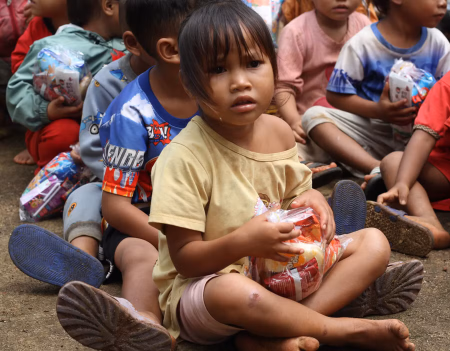 Hình ảnh những em bé vùng khó tay ôm khư khư gói bim bim, ăn ngon lành cái kẹo khiến mọi người phải suy ngẫm. Ảnh: Hoàng Hoài