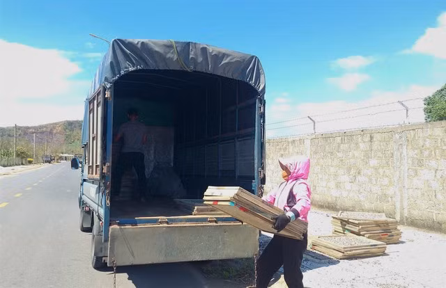 Người dân thu lại các vỉ cá duội xếp lên xe sau khi phơi đủ 2 nắng ở Lao Bảo