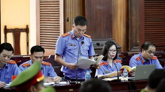 Kiểm sát viên Ngô Phạm Việt đọc cáo trạng. Trong vụ án Trương Mỹ Lan, có 10 kiểm sát viên của KSND tối cao và Viện KSND TP.HCM tham gia phiên tòa, gồm: ông Cao Anh Đức, ông Đặng Như Vĩnh, ông Vũ Mạnh Long, ông Vũ Tất Ba, bà Nguyễn Thị Hồng Vân, bà Đặng Thị Hồng Thủy, ông Lưu Hoàng Tuấn, ông Nguyễn Đức Long, ông Ngô Phạm Việt, ông Nguyễn Hồng Hiệp. Kiểm sát viên Ngô Phạm Việt đọc cáo trạng. Trong vụ án Trương Mỹ Lan, có 10 kiểm sát viên của KSND tối cao và Viện KSND TP.HCM tham gia phiên tòa, gồm: ông Cao Anh Đức, ông Đặng Như Vĩnh, ông Vũ Mạnh Long, ông Vũ Tất Ba, bà Nguyễn Thị Hồng Vân, bà Đặng Thị Hồng Thủy, ông Lưu Hoàng Tuấn, ông Nguyễn Đức Long, ông Ngô Phạm Việt, ông Nguyễn Hồng Hiệp.