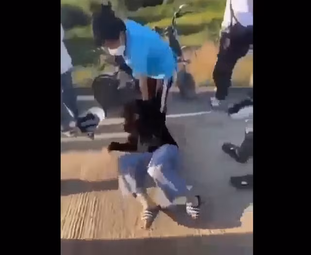 T.N.T.T. bị nhóm nữ sinh dùng mũ bảo hiểm đánh tới tấp. Ảnh cắt từ clip