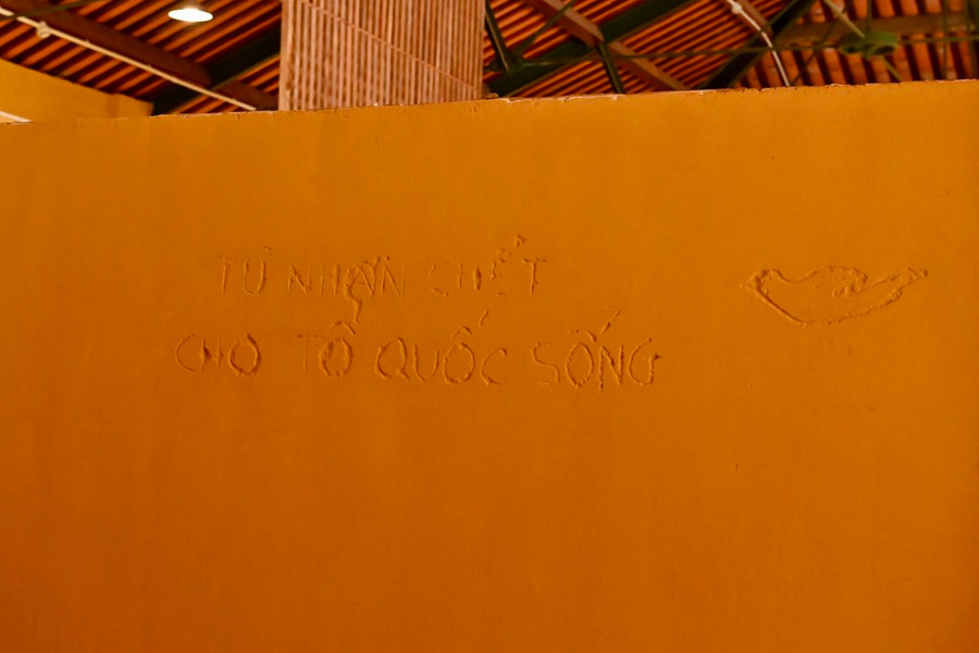 Dòng chữ do các chiến sĩ cách mạng viết trên tường phòng giam. Ảnh: VIỆT DŨNG