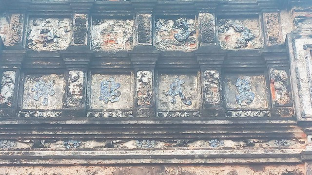 Mặt bên trong nghi môn có 4 chữ: "Vạn đại chiêm ngưỡng", nghĩa là: vạn năm ai đi qua cũng phải ngước nhìn. Tất cả các chữ này đều được ghép từ mảnh sứ từ những chiếc chén, bát cổ thời nhà Nguyễn. Mặt bên trong nghi môn có 4 chữ: "Vạn đại chiêm ngưỡng", nghĩa là: vạn năm ai đi qua cũng phải ngước nhìn. Tất cả các chữ này đều được ghép từ mảnh sứ từ những chiếc chén, bát cổ thời nhà Nguyễn.