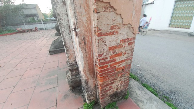 Cổng phụ nghi môn bị bong tróc lớp vữa trát phủ bên ngoài Cổng phụ nghi môn bị bong tróc lớp vữa trát phủ bên ngoài