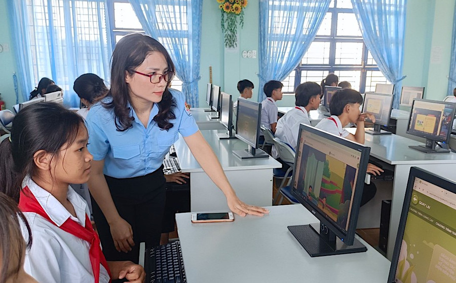 Cô Võ Thị Tám-giáo viên Tổng phụ trách Đội Trường THCS Dân tộc Nội trú huyện Kông Chro hướng dẫn học sinh tham gia sinh hoạt Đội số tại phòng Tin học của trường. Ảnh: Mộc Trà