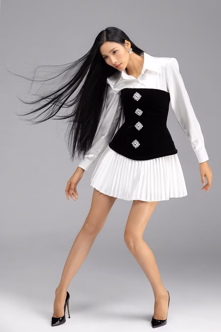 Chỉ cần mặc corset bên ngoài trang phục công sở gồm sơ mi trắng và chân váy xếp ly, Hoàng Thùy đã có bộ cánh dự tiệc ấn tượng