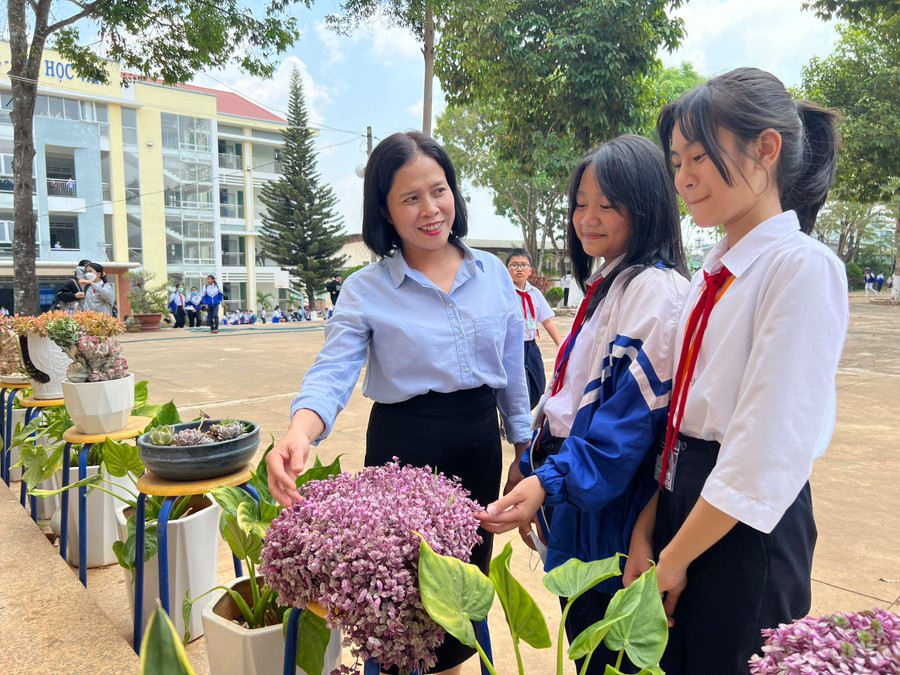 Giáo viên và học sinh Trường THCS Trần Phú tìm hiểu quy trình trồng và chăm sóc các loại hoa ở sân trường. Ảnh: Phan Lài