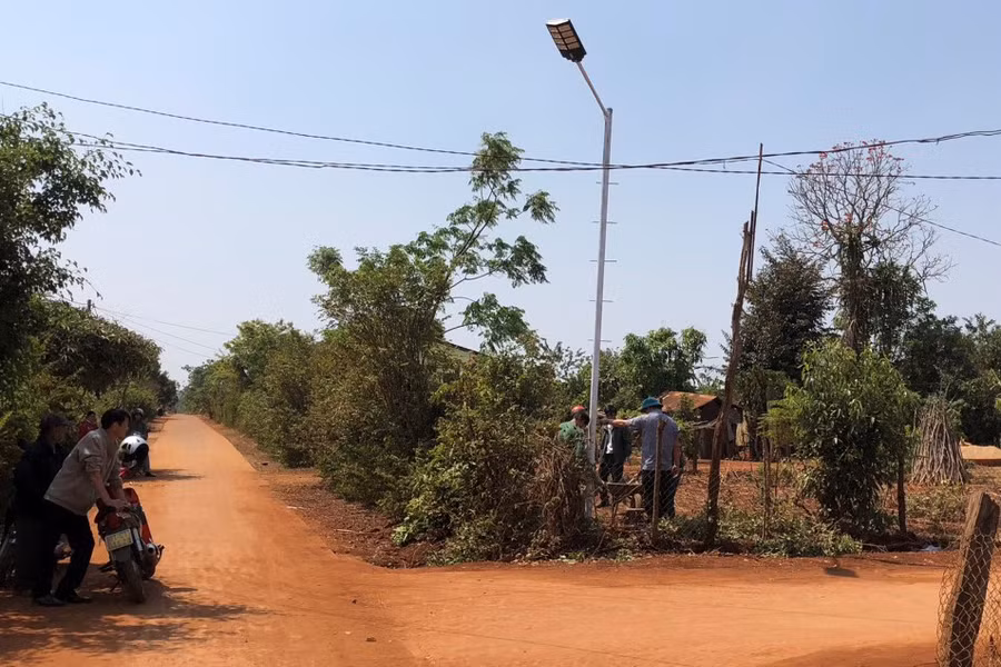Người dân làng Biă Bre cùng tham gia dựng các trụ đèn điện năng lượng mặt trời dọc tuyến đường làng. Ảnh: Anh Huy
