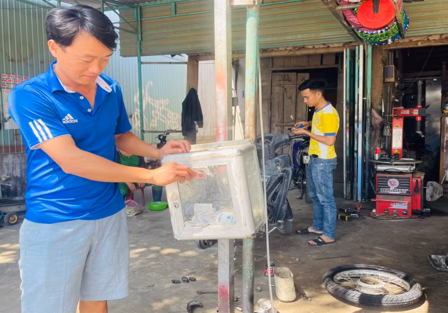 Anh Nguyễn Kim Hải-Bí thư Đoàn trường THPT Trần Quốc Tuấn ủng hộ tiền sau mỗi lần sửa xe. Ảnh: Vũ Chi