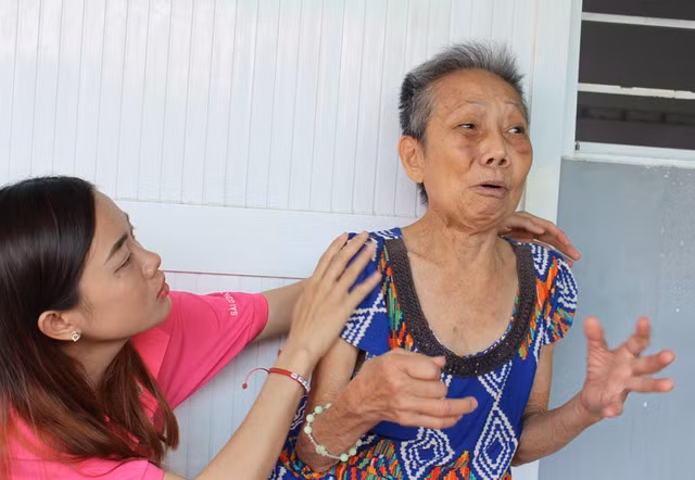 Một tình nguyện viên động viên, an ủi cụ Lương Lệ Thanh. Ảnh: Quang Viên