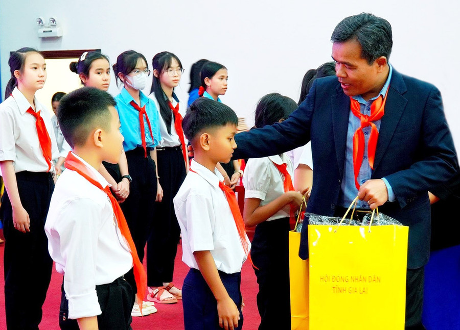 Ủy viên Ban Chấp hành Trung ương Đảng, Bí thư Tỉnh ủy, Chủ tịch HĐND tỉnh Hồ Văn Niên tặng quà cho thiếu nhi tham gia chương trình tiếp xúc, đối thoại. Ảnh: Đức Thụy