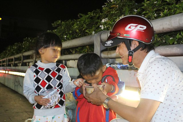 Hai em bé vô gia cư hí hửng nhận lấy tô cháo từ phóng viên Báo Thanh Niên Hai em bé vô gia cư hí hửng nhận lấy tô cháo từ phóng viên Báo Thanh Niên