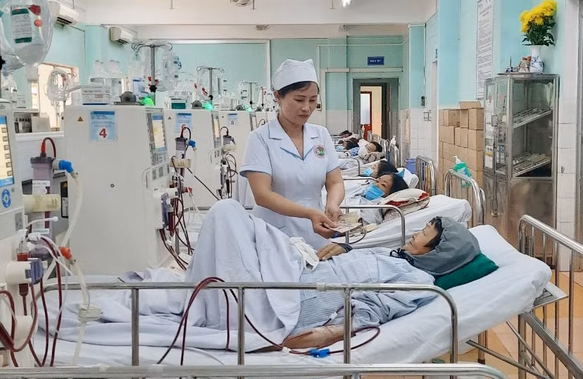 Điều dưỡng viên Nguyễn Thị Thanh Phương trao tiền hỗ trợ của Mạnh Thường Quân cho bệnh nhân nghèo. Ảnh: Như Nguyện