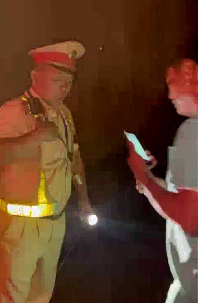 Bắt khẩn cấp lái xe giật bảng tên của CSGT - Ảnh 1. Người đàn ông giật bảng tên 1 chiến sĩ CSGT. Ảnh cắt từ clip