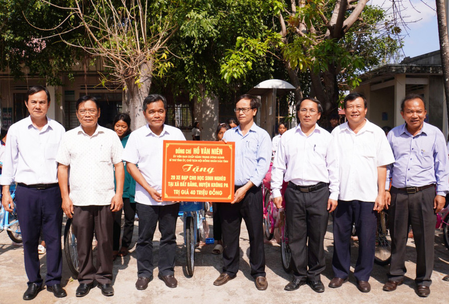 Bí thư Tỉnh ủy Hồ Văn Niên (thứ 5 từ phải sang) tặng 20 chiếc xe đạp cho học sinh nghèo xã Đất Bằng, huyện Krông Pa. Ảnh: Đức Thụy