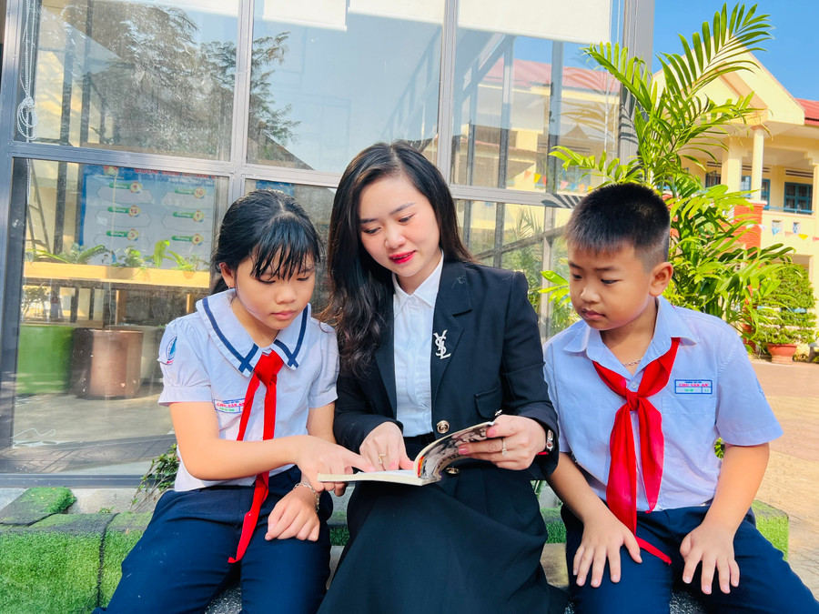 Giáo viên và học sinh Trường Tiểu học Chu Văn An đọc sách trước thư viện xanh. Ảnh: Phan Lài