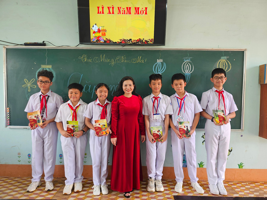Học sinh lớp 6/3, Trường THCS Nguyễn Du (phường Ia Kring, TP. Pleiku) vui vẻ nhận sách và phong bao lì xì năm mới từ cô giáo chủ nhiệm. Ảnh: Mộc Trà Học sinh lớp 6/3, Trường THCS Nguyễn Du (phường Ia Kring, TP. Pleiku) vui vẻ nhận sách và phong bao lì xì năm mới từ cô giáo chủ nhiệm. Ảnh: Mộc Trà